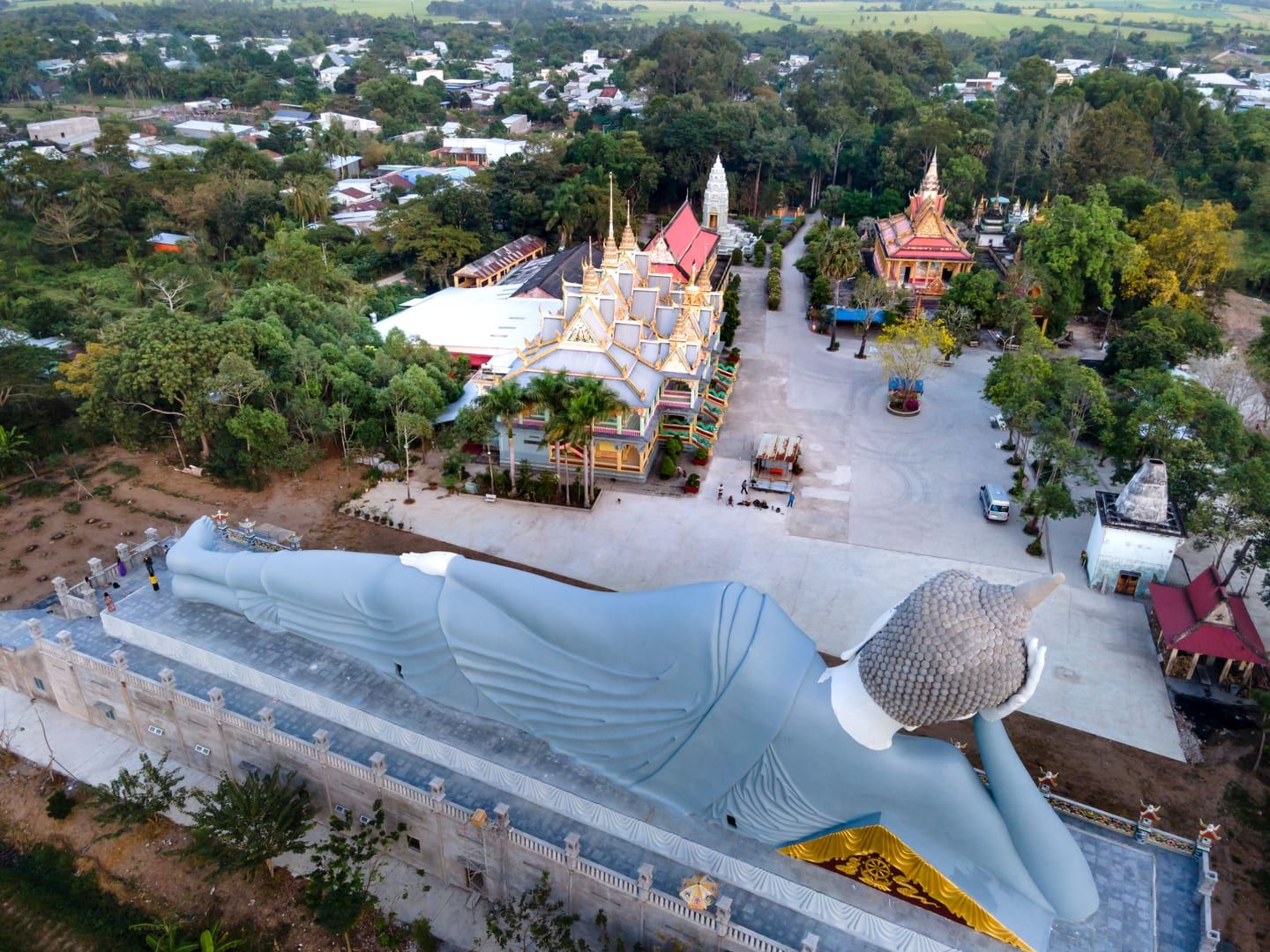 Golden reclining Buddha statue surrounded by dense tropical forest on Koh Samui