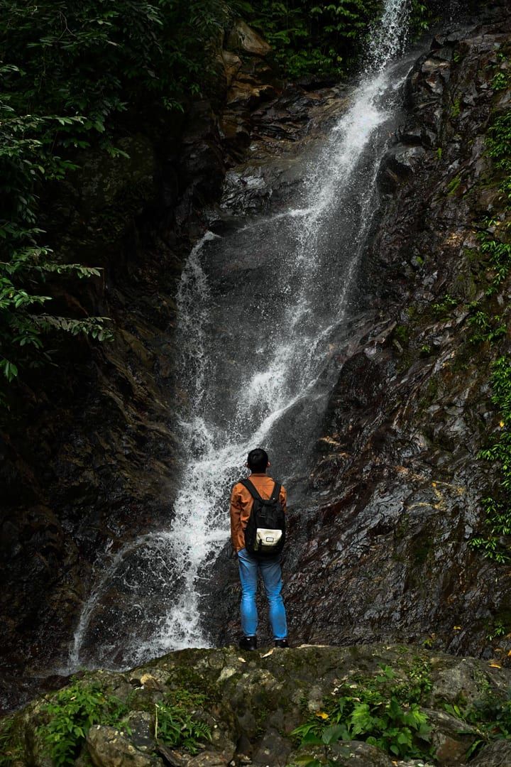 Hiker admiring a jungle waterfall along the Tan Rua Trail on Koh Samui