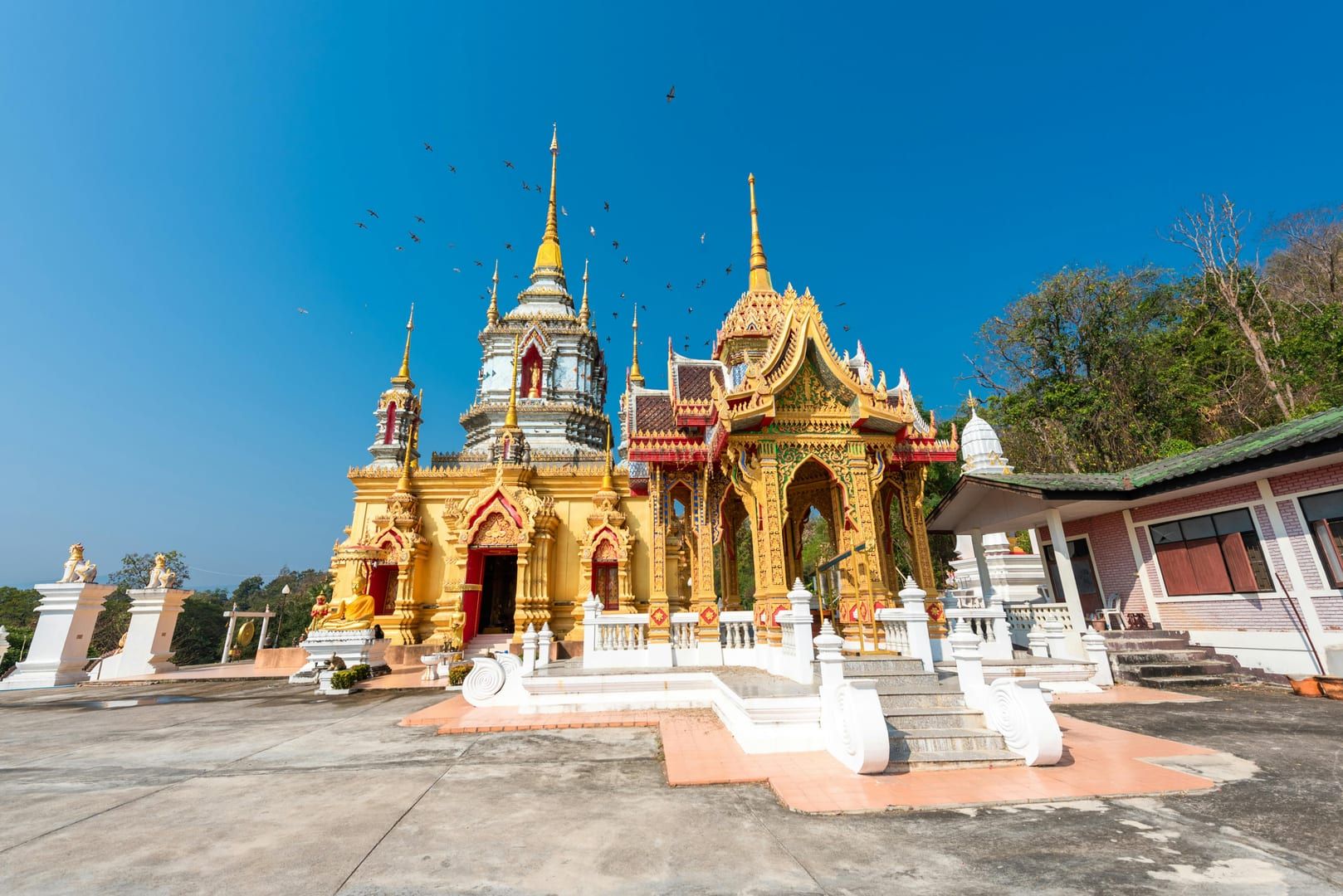 Evening light on the golden statues of Wat Khao Chedi