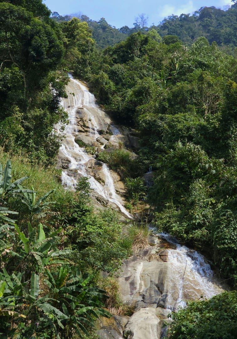 Water cascading over rocks in a shaded jungle setting at Khao Yai