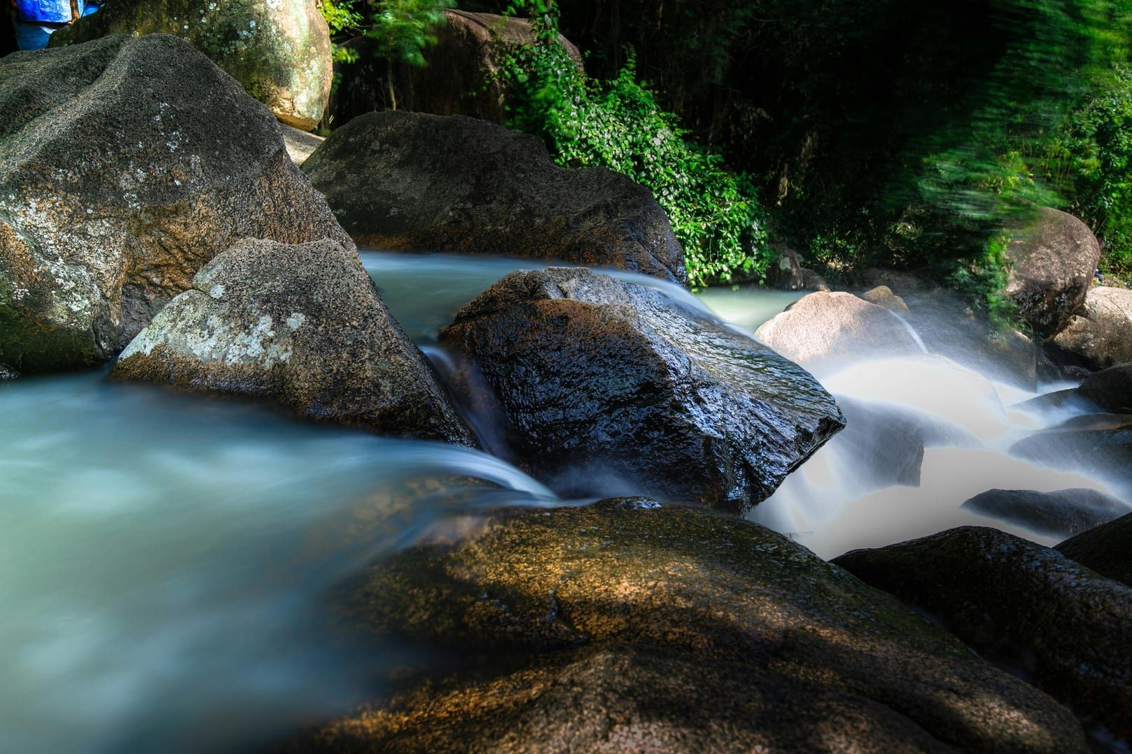 Peaceful stream over mossy rocks in Na Muang forest park Koh Samui