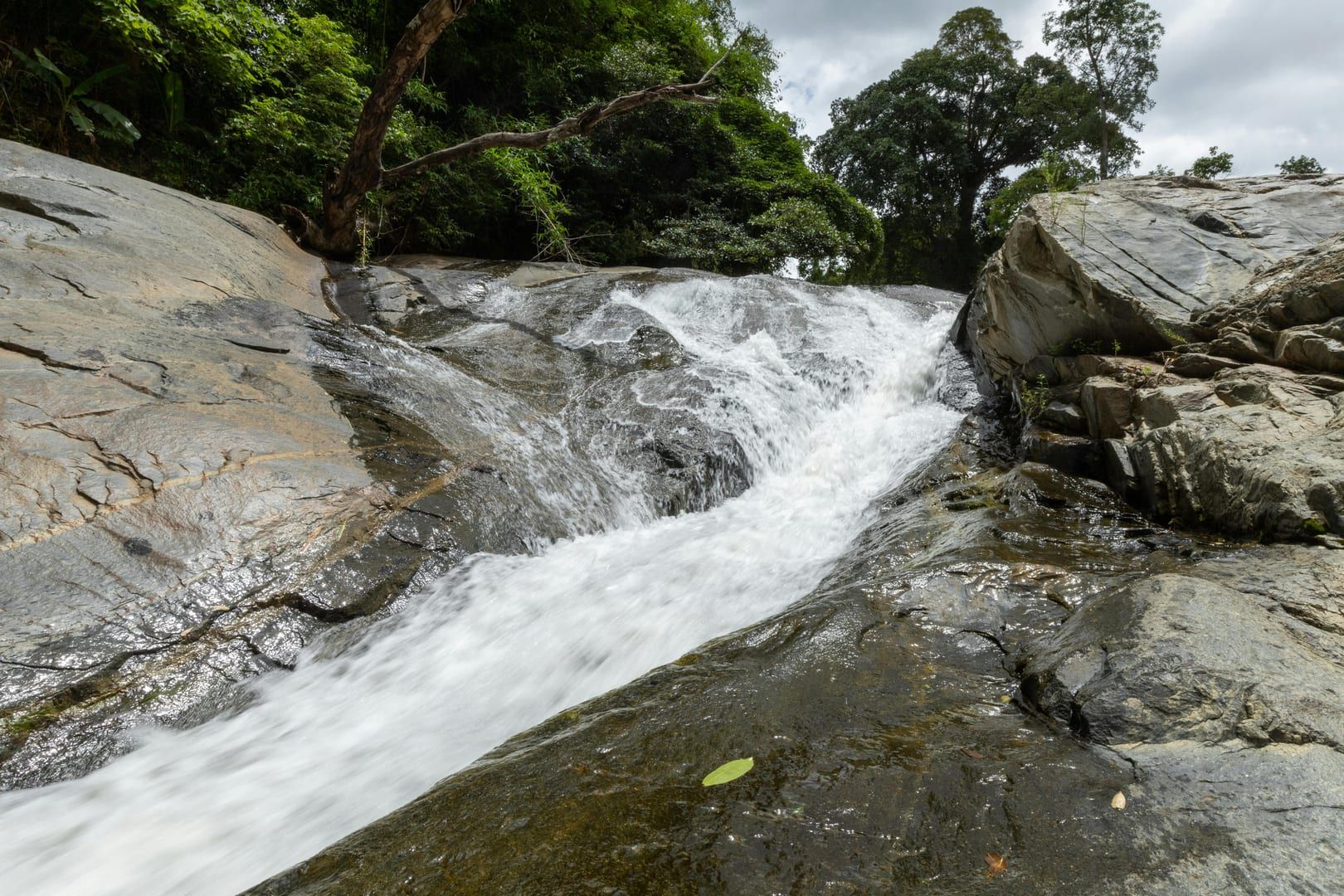 Waterfall streaming over rocks in lush jungle forest near Na Muang Koh Samui