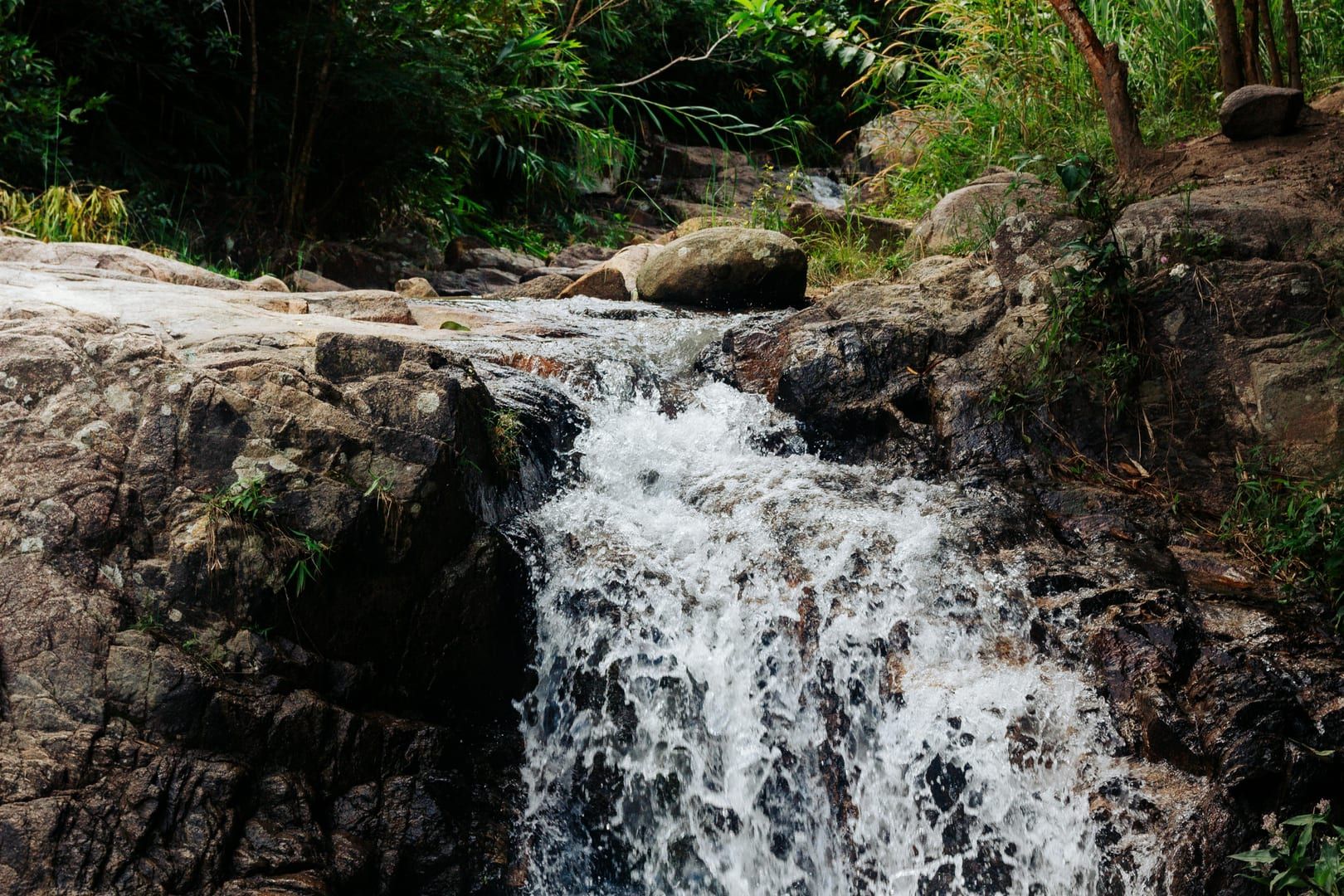 Waterfall flowing over rocks in lush greenery at best waterfalls Koh Samui