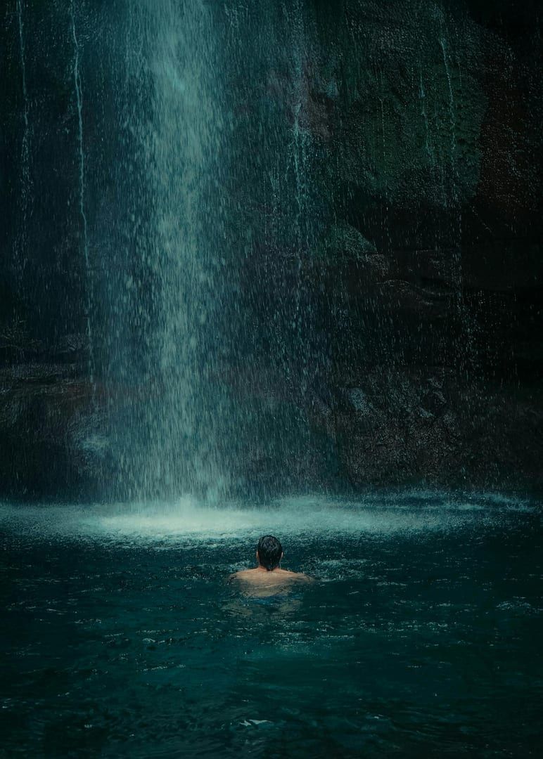 Person swimming in natural pool at Secret Buddha Garden waterfall Koh Samui hidden attraction